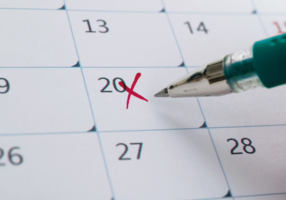 Mit einem Stift wird ein Kreuz in den Kalender gemacht