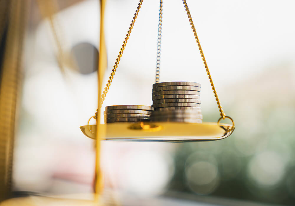 Münzen stapeln sich auf einer Waage