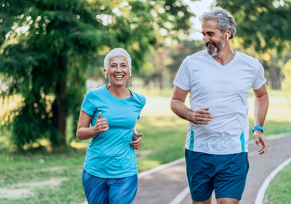 Älteres Paar lächelnd beim Joggen