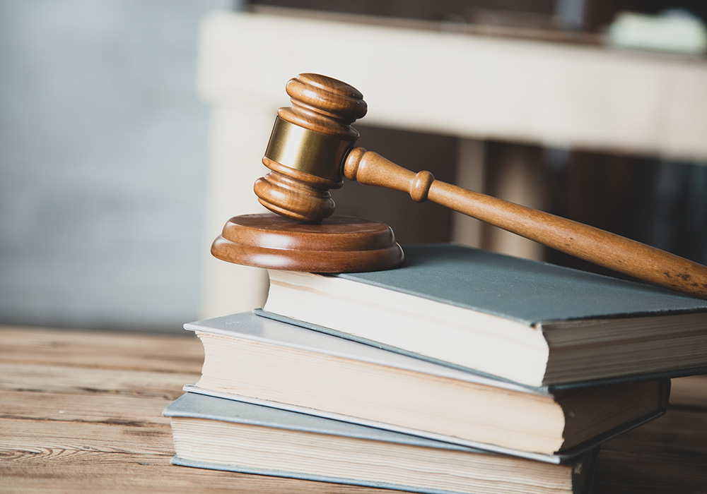 Holzhammer auf Gesetzesbüchern auf dem Schreibtisch